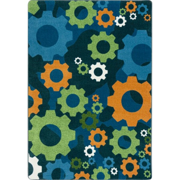 A Joy Carpets rectangular area rug with a colorful pattern of gears in blue and orange on a citrus background.