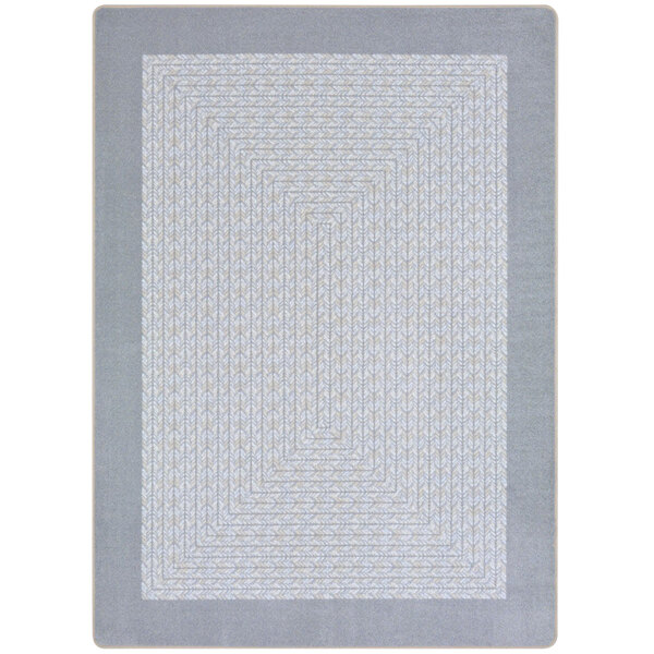 A close-up of the gray and white geometric pattern on a Joy Carpets rectangular area rug.