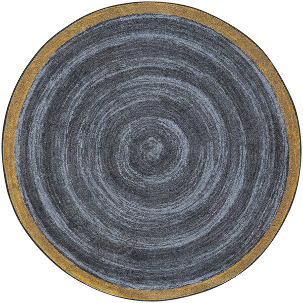 A close up of a grey circle with a yellow border on a slate round area rug.