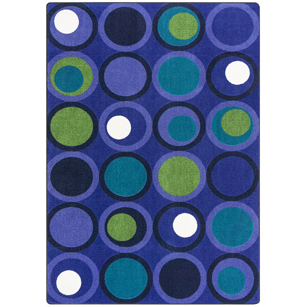 A blue and green rug with circle patterns, including white circles.