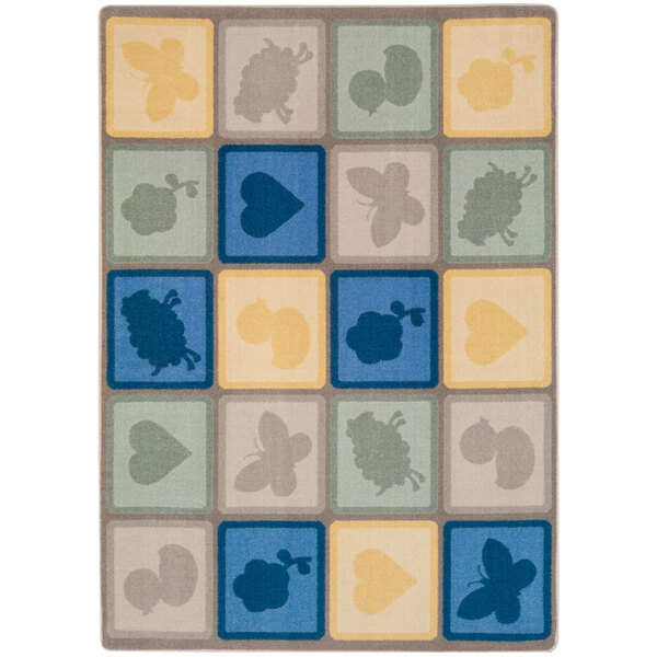 A close-up of a Joy Carpets area rug with various shapes and colors including squares, circles, and a butterfly on a blue background.