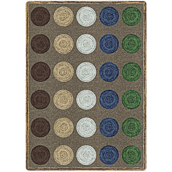 A close-up of a multicolored Joy Carpets rectangular area rug with circles and dots in brown, green, and blue.