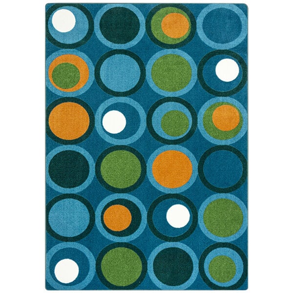 A blue rug with green, orange, and white circles.