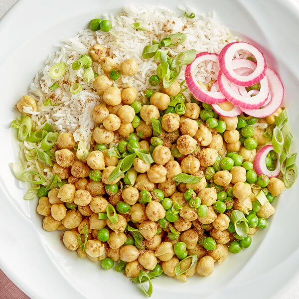 A bowl of rice and peas with a plate of chickpeas next to a container of Regal Garam Masala.