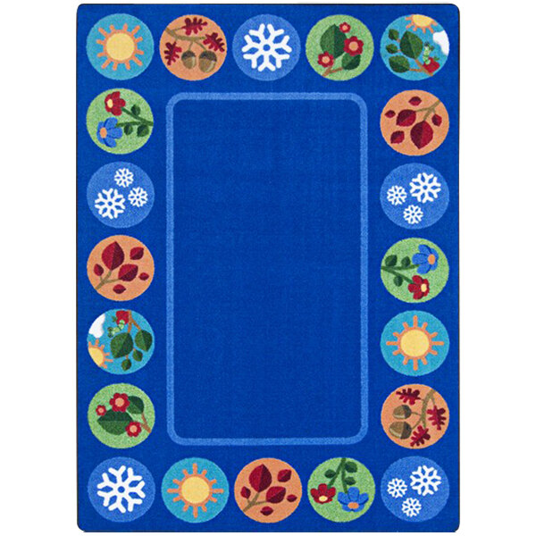 A blue rectangular area rug with white lines, colorful circles, and flowers.