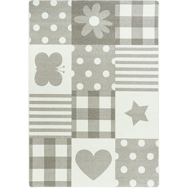 A rug with a grey and white patchwork pattern including a butterfly, heart, star, and flower.