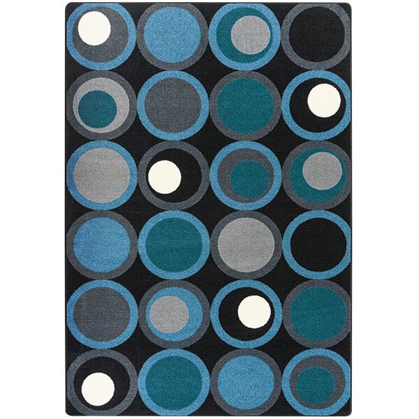 A Joy Carpets Kid Essentials Sapphire area rug with black, blue, and grey circles on it.