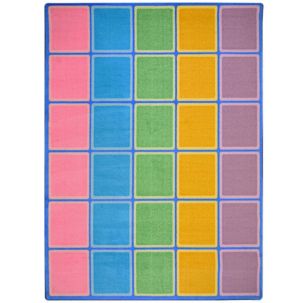 A pastel area rug with colorful squares, rectangles, and borders in pink, blue, green, and yellow.
