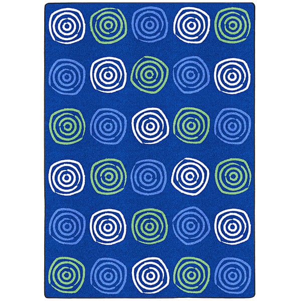 A blue rug with white and green swirls and circles.