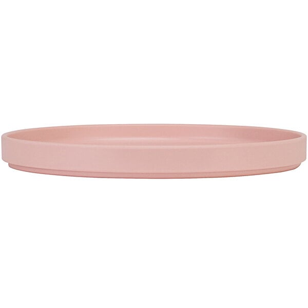 A Cal-Mil blush pink melamine plate with a low circular rim.