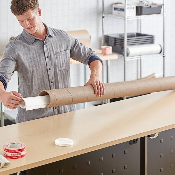 A man holding a Lavex Kraft heavy-duty mailing tube.