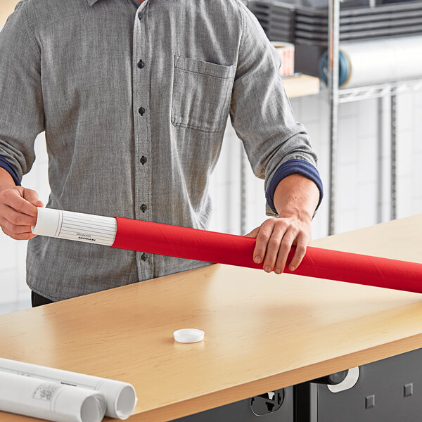 A man holding a red Lavex mailing tube