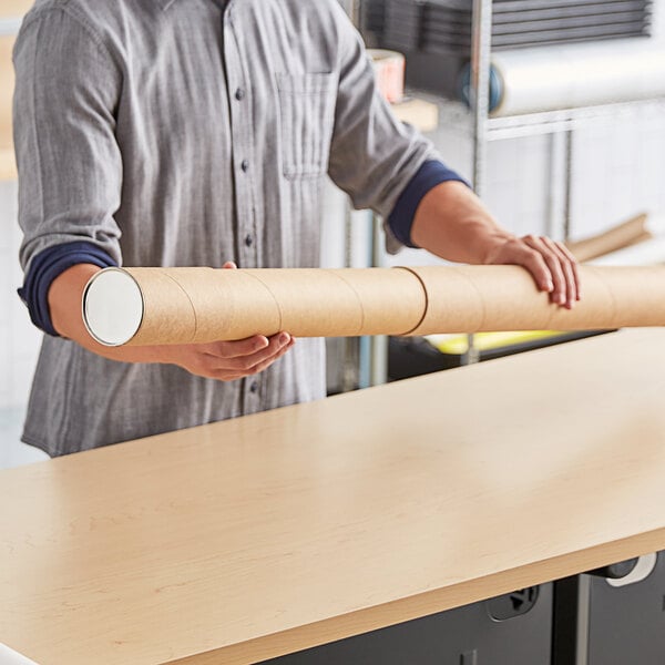 A person holding a Lavex kraft telescoping mailing tube