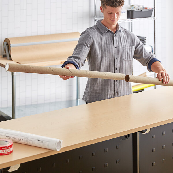 A man holding a long white Lavex Kraft mailing tube.