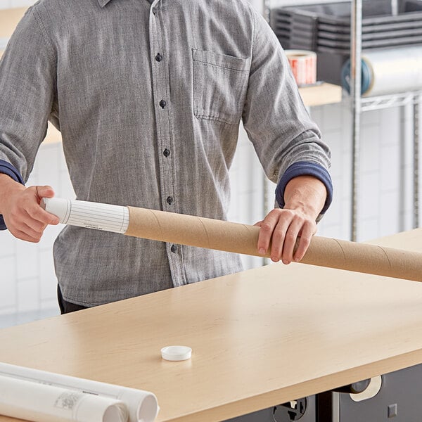 A man holding a long Kraft mailing tube.