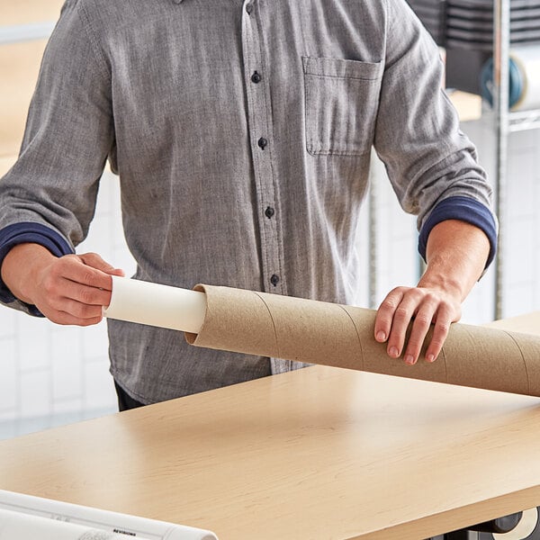 A person holding a Lavex cardboard mailing tube.