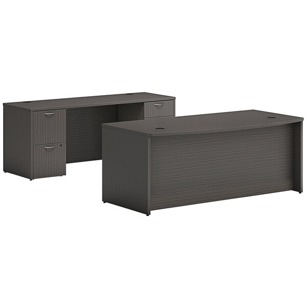 A slate teak laminate bow front desk with credenza and two storage pedestals.
