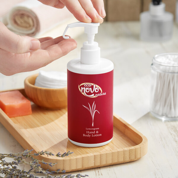 A hand holding a white pump of Noble Eco Novo Natura hand lotion.