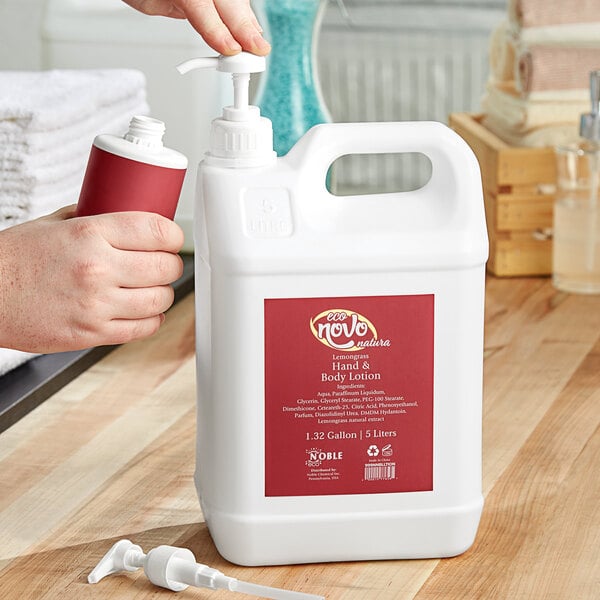 A person pouring Noble Eco Novo Natura hand and body lotion into a white plastic container.