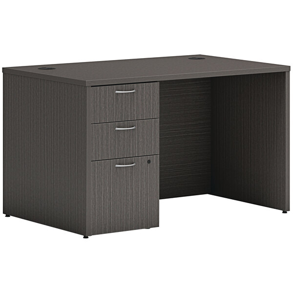 A black Hon Mod laminate desk with drawers and a cabinet.