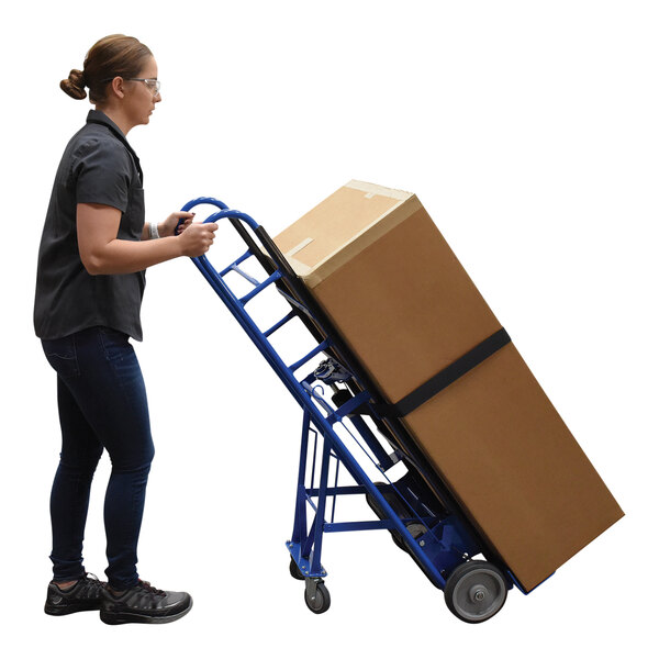 A woman using a Vestil appliance hand truck to move a large box.