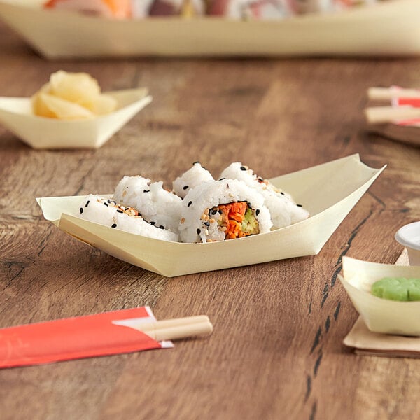 A wooden food boat filled with sushi on a table.