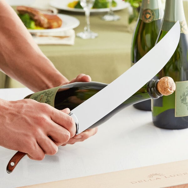 A person using a Della Luce Sedona champagne saber to open a bottle of wine.
