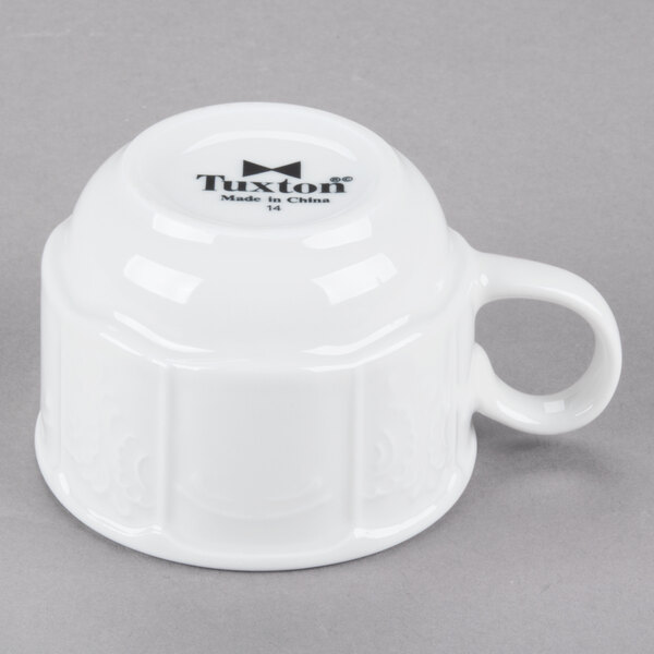 A Tuxton bright white stackable china cup with a handle.