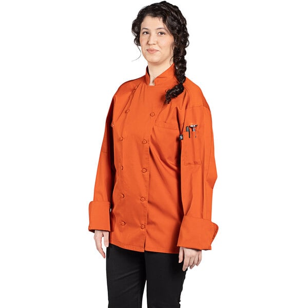 A close-up of a Uncommon Chef orange chef coat with mesh back.