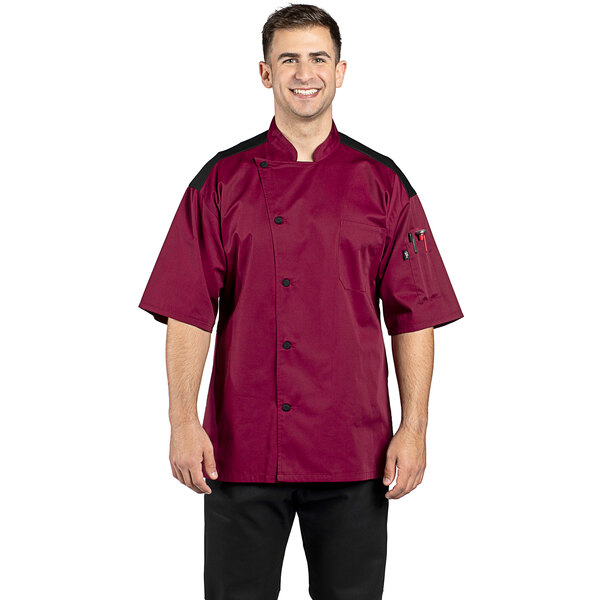 A man wearing a burgundy and white Uncommon Chef Rogue Pro Vent chef coat with a mesh back.