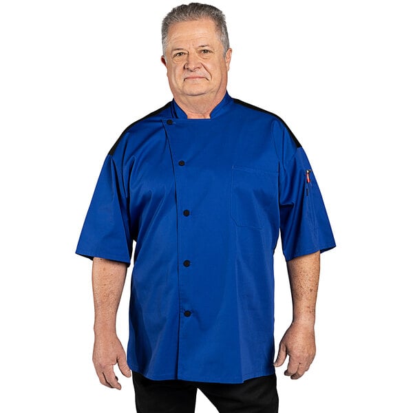 A man wearing a royal blue Uncommon Chef Rogue Pro Vent chef coat with mesh back.