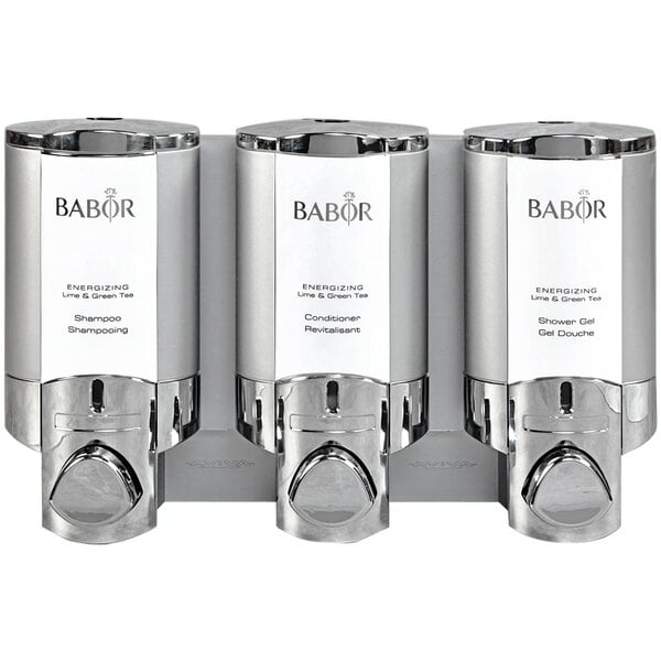 A room with a chrome Dispenser Amenities Aviva 3-chamber wall-mounted soap dispenser with satin silver bottles.