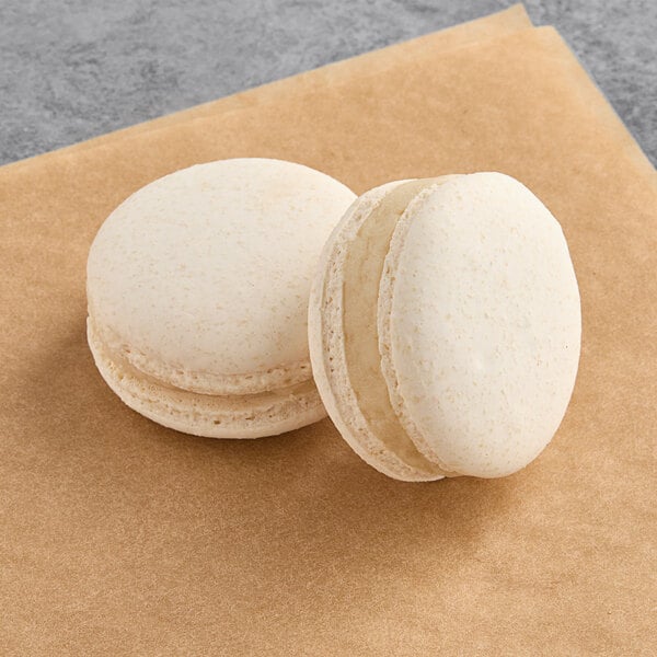 Two Macaron Centrale vegan vanilla sea salt macarons with white filling.