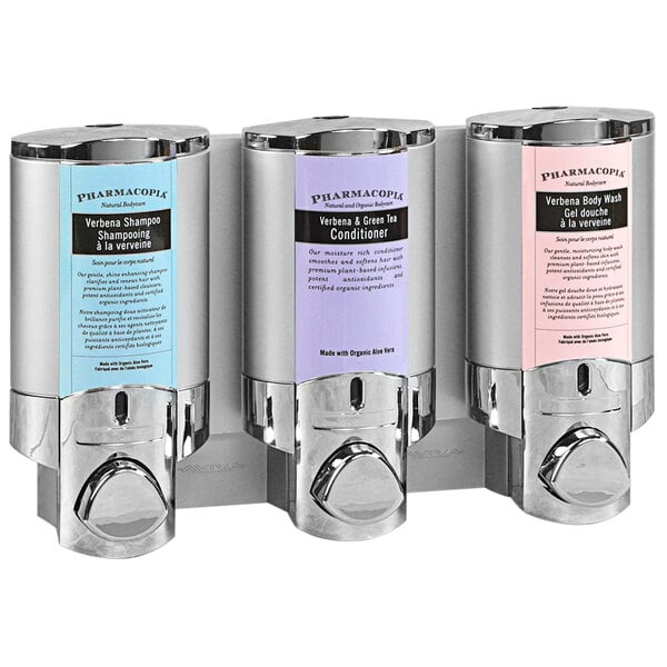 A chrome wall mounted Dispenser Amenities Aviva 3-chamber shower dispenser with translucent bottles.