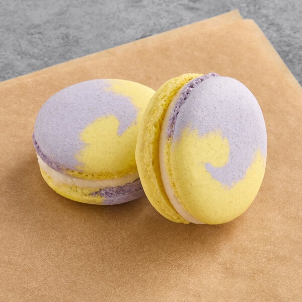 Two Macaron Centrale honey lavender macarons on a piece of paper.