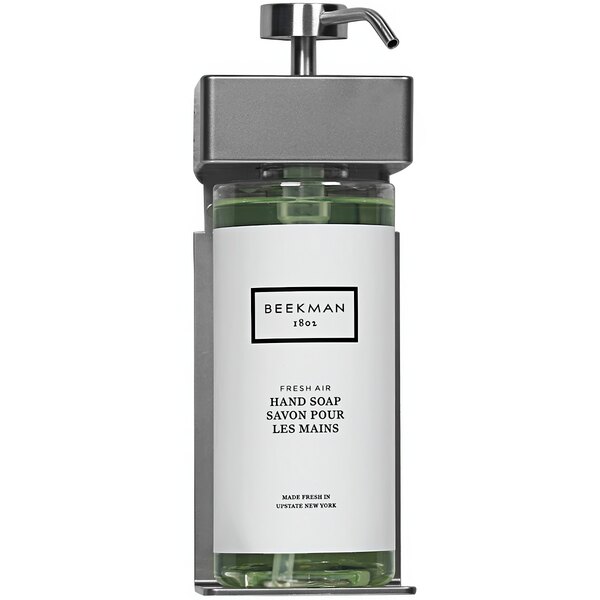A black Dispenser Amenities wall-mounted soap dispenser with an oval bottle and a white Beekman label.