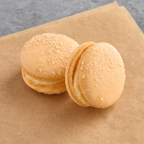 Two Macaron Centrale vegan mango coconut macarons on a brown paper.