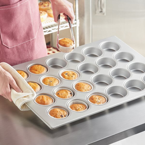 A woman using a Baker's Mark jumbo muffin pan to make muffins.