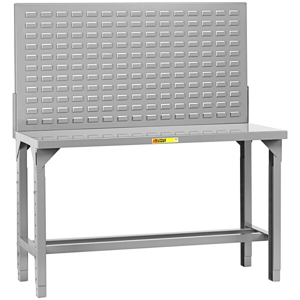 A grey metal work bench with a metal grid on the back.