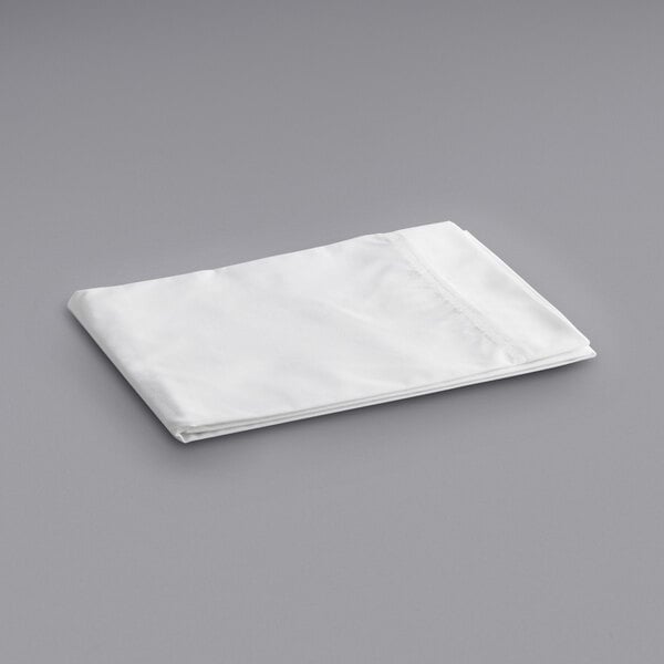 A folded white Oxford Superblend pillow case on a gray surface.