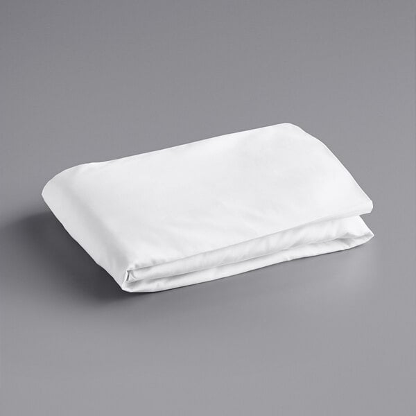A folded white Oxford Super queen size fitted sheet on a gray surface.