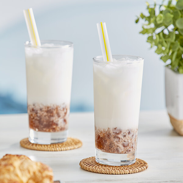 Two glasses of milk with yellow and white straws with Bossen Lychee Powder Mix.
