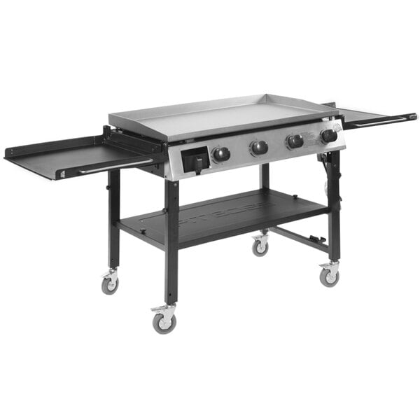 A Pit Boss gas griddle on a table with a shelf.