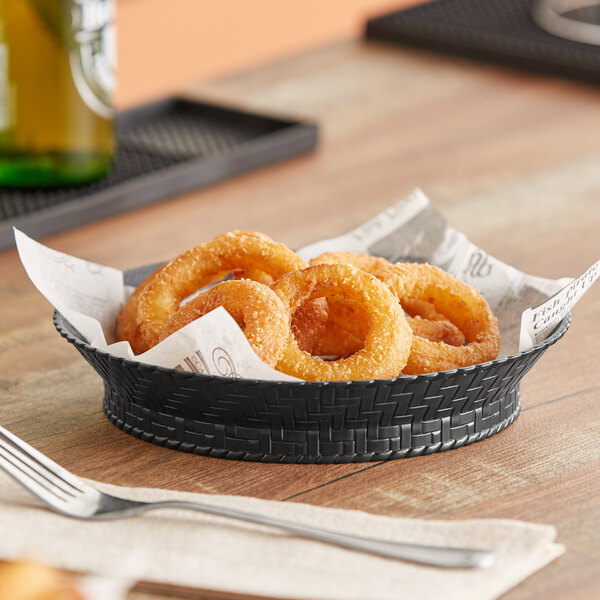 A black plastic round fast food basket filled with fried onion rings.