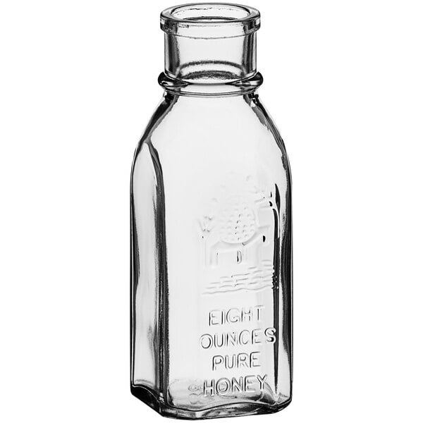 A clear glass Muth honey jar with a cap.