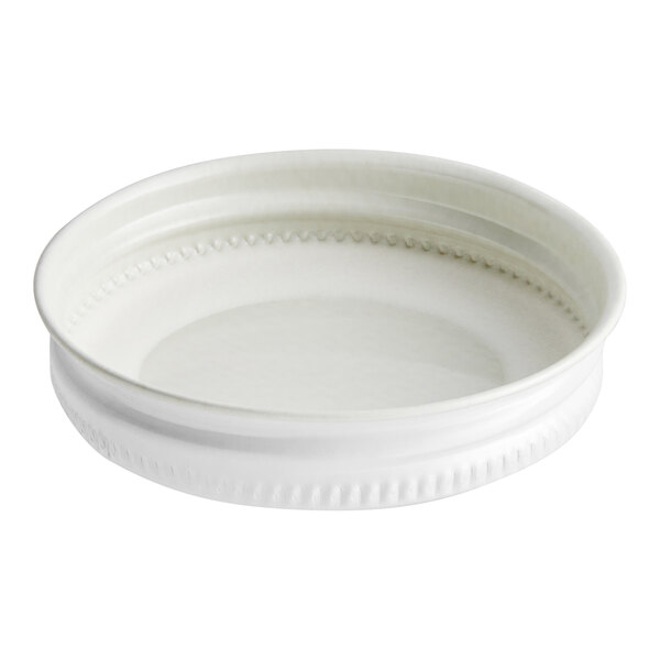 A white metal lid with a white plastisol liner on a white surface.