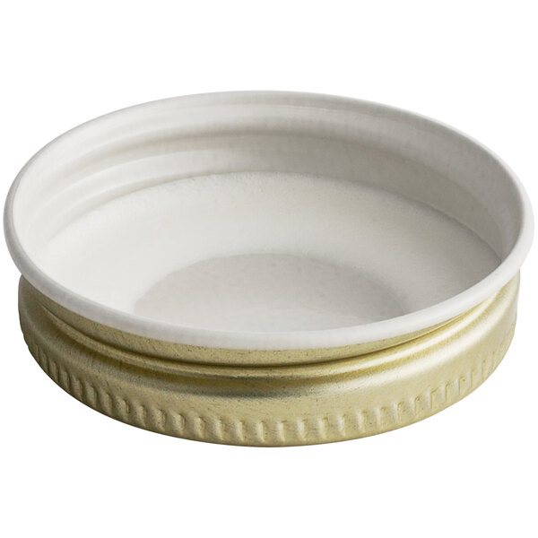 A 38/400 gold metal lid with a plastisol liner with a gold rim on a white surface.
