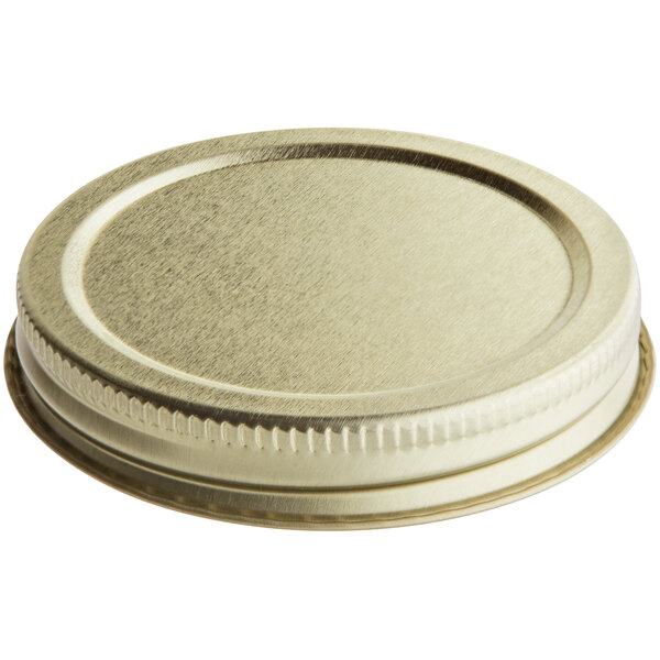 A close up of a 63/400 gold metal lid with plastisol liner.