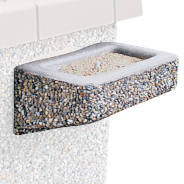 A close-up of a stone bowl set in a concrete square.