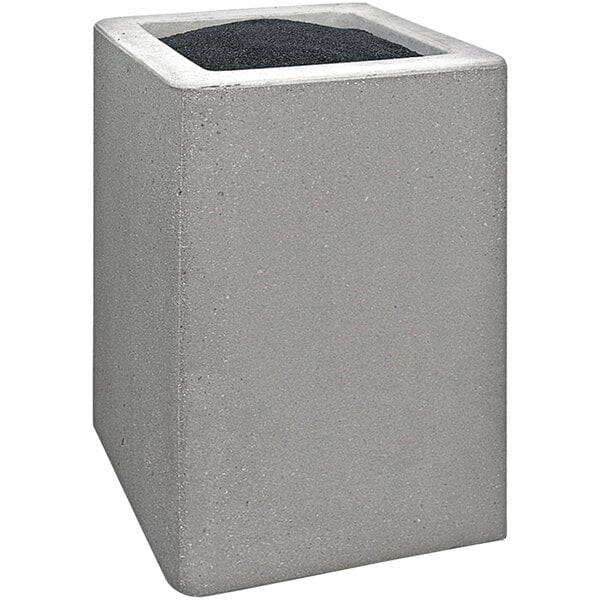 A grey concrete cube with a black top.